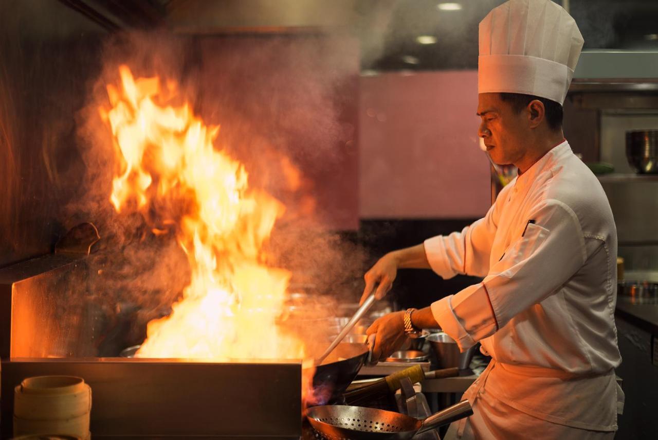 The Berkeley Hotel Pratunam Бангкок Экстерьер фото A chef cooking with a wok